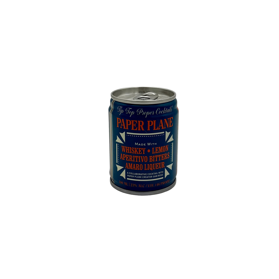 Can of Paper Plane cocktail. The appearance of the can is dark indigo with red text 'Whiskey, Lemon, Aperitivo bitters, Amaro Liqueur' on a white background